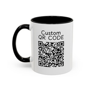 May include: White ceramic mug with a black rim and handle. The mug features a black and white QR code with the text "Custom QR Code" above it.