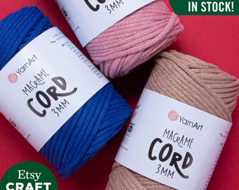 May include: Three spools of 3mm macrame cord in pink, blue, and beige. The spools are labeled "YarnArt Macrame Cord 3mm". The text "ALL COLORS IN STOCK!" is in the upper right corner of the image.
