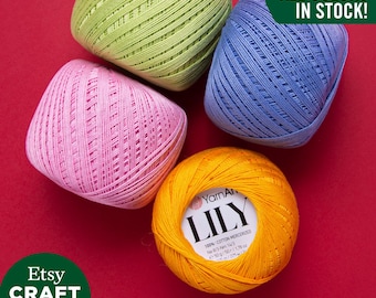 May include: Four balls of yarn in different colors: green, pink, blue, and orange. The orange ball has a label that reads "YarnArt LILY 100% Cotton Mercerized No 8/3 - Nen 14/3 50g / 50 / 1.76 oz - 175 m / 192 yd". The text "ALL COLORS IN STOCK!" is in the upper right corner of the image.