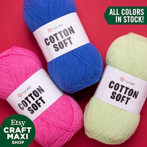 May include: Three balls of YarnArt Cotton Soft yarn in blue, pink, and green. The label reads "YarnArt Cotton Soft". The text "ALL COLORS IN STOCK!" is in a green box.