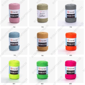 Op de afbeelding: Assortiment van 10 spoelen macram&eacute; katoenen koord in verschillende kleuren, waaronder roze, groen, grijs, blauw, oranje, geel, limoengroen en roze. Elke spoel is gelabeld met "YarnArt Macrame Cotton".