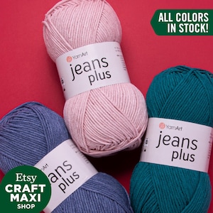 Op de afbeelding: Vier bollen YarnArt Jeans Plus garen in roze, teal, blauw en denim blauw. Het label vermeldt "YarnArt Jeans Plus" en "Alle kleuren op voorraad!"