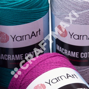 Op de afbeelding: Drie spoelen garen in verschillende kleuren: teal, grijs en magenta. Elke spoel heeft een wit label met de tekst "YarnArt" en "Macrame Cotton" erop gedrukt.