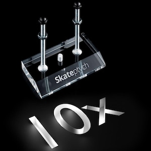 Puede incluir: Soporte de exhibición de acrílico transparente con dos pernos y el texto "Skateptych". El número "10X" se muestra debajo. El fondo es negro.