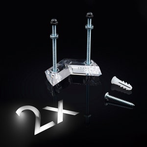 Op de afbeelding: Twee transparante hoekbeugels van kunststof met zwarte schroefkappen en zilveren schroeven. De beugels zijn gemarkeerd met "Arcorus". De afbeelding toont ook twee witte kunststof wandpluggen en een zilveren schroef.