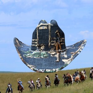Puede incluir: Un sombrero de vaquero azul con un dise&ntilde;o impreso de vaqueros montando a caballo. El sombrero tiene un ala ancha y una corona puntiaguda.