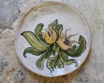 The “Medlar” plate is a handmade unique piece. The ceramic, fired several times, is hand-painted and glazed. With antique craquele finish