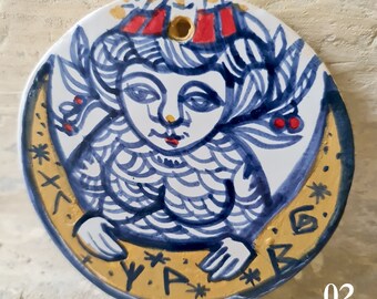 Wisiorek "Hulda", ceramiczny, wykonany z białej gliny, majoliki z elementami w kolorze niebieskim, białym i złotym, ręcznie malowany, wielokrotnie wypalany.