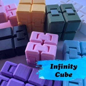 May include: A selection of multi-coloured Infinity Cubes, including pink, yellow, green, black, blue, and purple. The text "Infinity Cube" is displayed on a blue background. These fidget toys are designed to provide tactile stimulation.