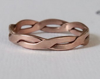 May include: A rose gold braided ring with a smooth, polished finish.