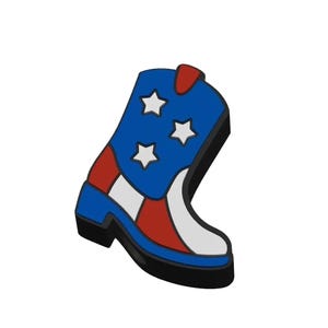 May include: A decorative pin shaped like a cowboy boot featuring a blue upper section with three white stars, a red and white striped lower section, and a solid blue heel. The design is outlined in black with a red pull tab at the top opening.