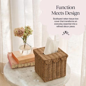 May include: A square, woven rattan tissue box cover in a light brown hue. The cover has a scalloped edge and holds white tissues. The text "Function Meets Design" is visible in the background.