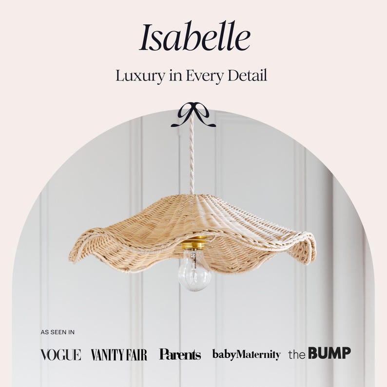 May include: A woven rattan pendant light with a scalloped edge, featuring a clear lightbulb and gold-toned hardware. The light is suspended from a white rope and a black bow. The text "Isabelle" and "Luxury in Every Detail" are at the top.