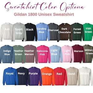 May include: A display of Gildan 1800 unisex sweatshirts in various colors, including Ash, Sport Gray, Black, Carolina Blue, Charcoal, Dark Chocolate, Forest Green, and Irish Green. Additional colors are Indigo Blue, Heather Green, Heather Maroon, Heliconia Pink, Light Blue, Light Pink, Maroon, and Military Green.
