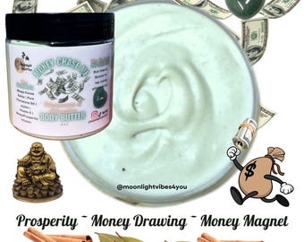Pode incluir: Um frasco de manteiga corporal "Money Chase Me" com tampa preta, rodeado por notas de dólar, uma pedra verde em forma de coração e um saco de dinheiro de desenho animado. O texto "Prosperity ~ Money Drawing ~ Money Magnet" está na parte inferior.