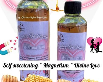 May include: Two glass bottles of "Dulce De Honey" spiritual bath with black caps and white labels. The labels have pink heart designs and text. Honeycombs and honey dippers are in the foreground. Text includes "Self sweetening ~ Magnetism ~ Divine Love".