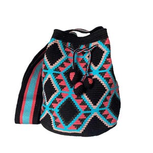 Peut inclure: Sac seau en crochet noir avec un motif géométrique rose, bleu et or. Le sac a une longue bandoulière et deux pompons noirs.