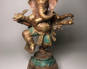 Op de afbeelding: Een gouden en groene metalen beeld van Ganesha, de hindoeïstische god van wijsheid en voorspoed, met vier armen en een kroon. Het beeld staat op een vierkante basis met ingewikkelde details.