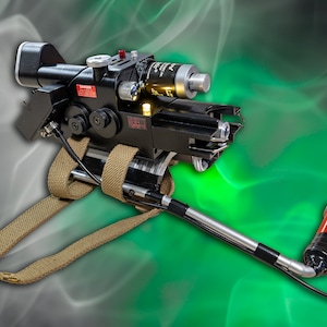 May include: A black and silver Ghostbusters proton pack with a tan strap and a red and black extension wand. The pack has a red warning label that says "DANGER".