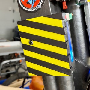 May include: A black and yellow striped safety barrier with a blue light and a red button. The barrier is attached to a metal pole with a sticker that says "Western Scolder Brothers Entertainment" and features two blue cartoon monsters.