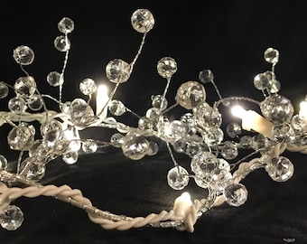 May include: A string of white fairy lights with clear crystal beads. The lights are strung on a white wire and are ideal for adding a touch of sparkle to any room.