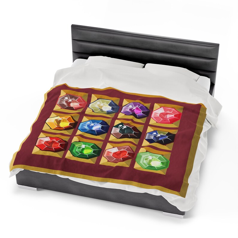 K&ouml;nnte beinhalten: Eine weinrote Decke mit einem Muster aus zw&ouml;lf farbigen Edelsteinen in Goldrahmen. Die Edelsteine haben verschiedene Farben, darunter Rot, Blau, Gr&uuml;n und Gelb. Die Decke liegt auf einem Bett mit wei&szlig;en Laken und einem schwarzen Kopfteil.