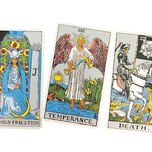 May include: Three tarot cards featuring detailed illustrations. The High Priestess card shows a woman in blue robes. The Temperance card depicts an angel. The Death card shows a knight on horseback. Each card has a title at the bottom.