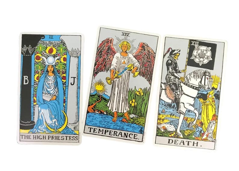 May include: Three tarot cards featuring detailed illustrations. The High Priestess card shows a woman in blue robes. The Temperance card depicts an angel. The Death card shows a knight on horseback. Each card has a title at the bottom.