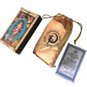 May include: A tarot deck box with a gold and brown design. The box features an illustration of the World card from the tarot deck. The box is labeled "Le Monde" and "Silver Cat Editions".