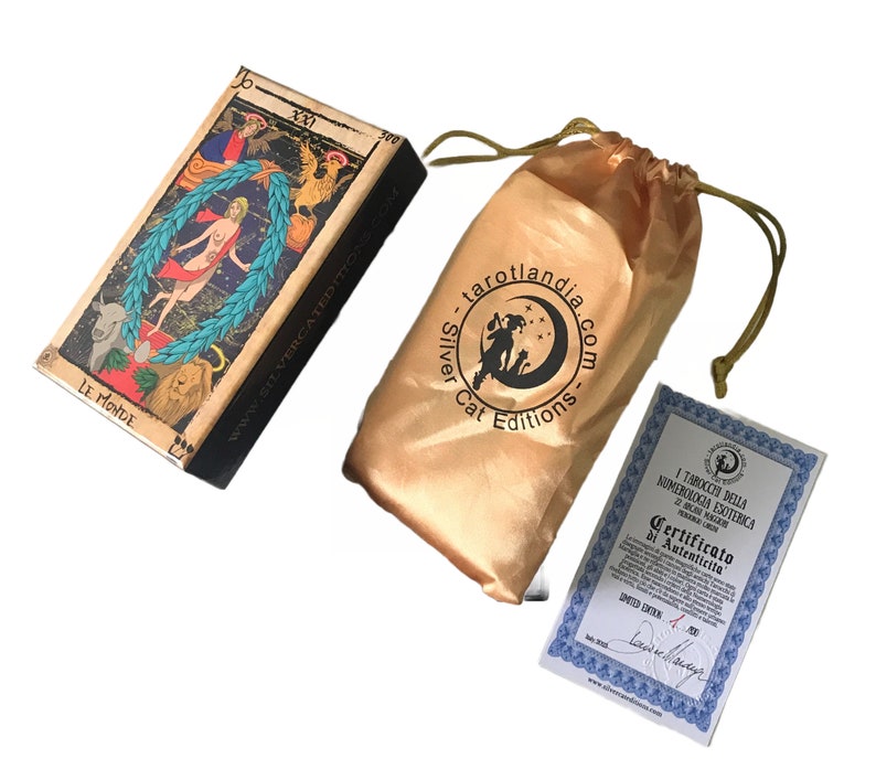 May include: A tarot deck box with a gold and brown design. The box features an illustration of the World card from the tarot deck. The box is labeled "Le Monde" and "Silver Cat Editions".