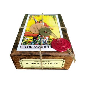May include: Wooden box with a tarot card design, tied with twine and sealed with a red wax stamp. The box features the text "THE MAGICIANS" and "RIDER WAITE SMITH". Includes a small tag that says "Handmade with love".