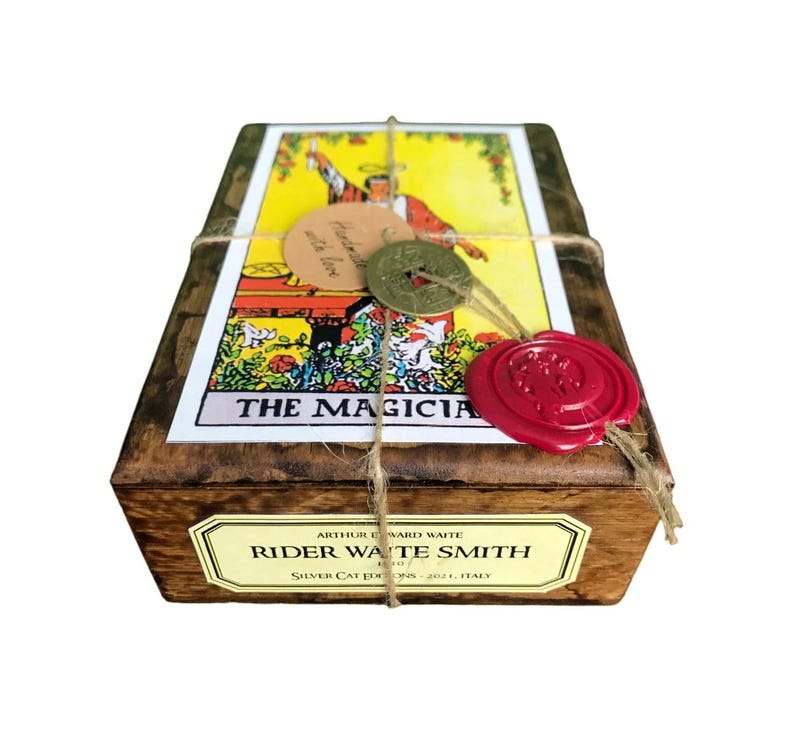 May include: Wooden box with a tarot card design, tied with twine and sealed with a red wax stamp. The box features the text "THE MAGICIANS" and "RIDER WAITE SMITH". Includes a small tag that says "Handmade with love".