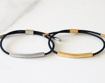 May include: Two black cord bracelets with adjustable closures. One bracelet has a silver bar with the inscription "PHI SIGMA SIGMA". The other bracelet has a gold bar with the same inscription.