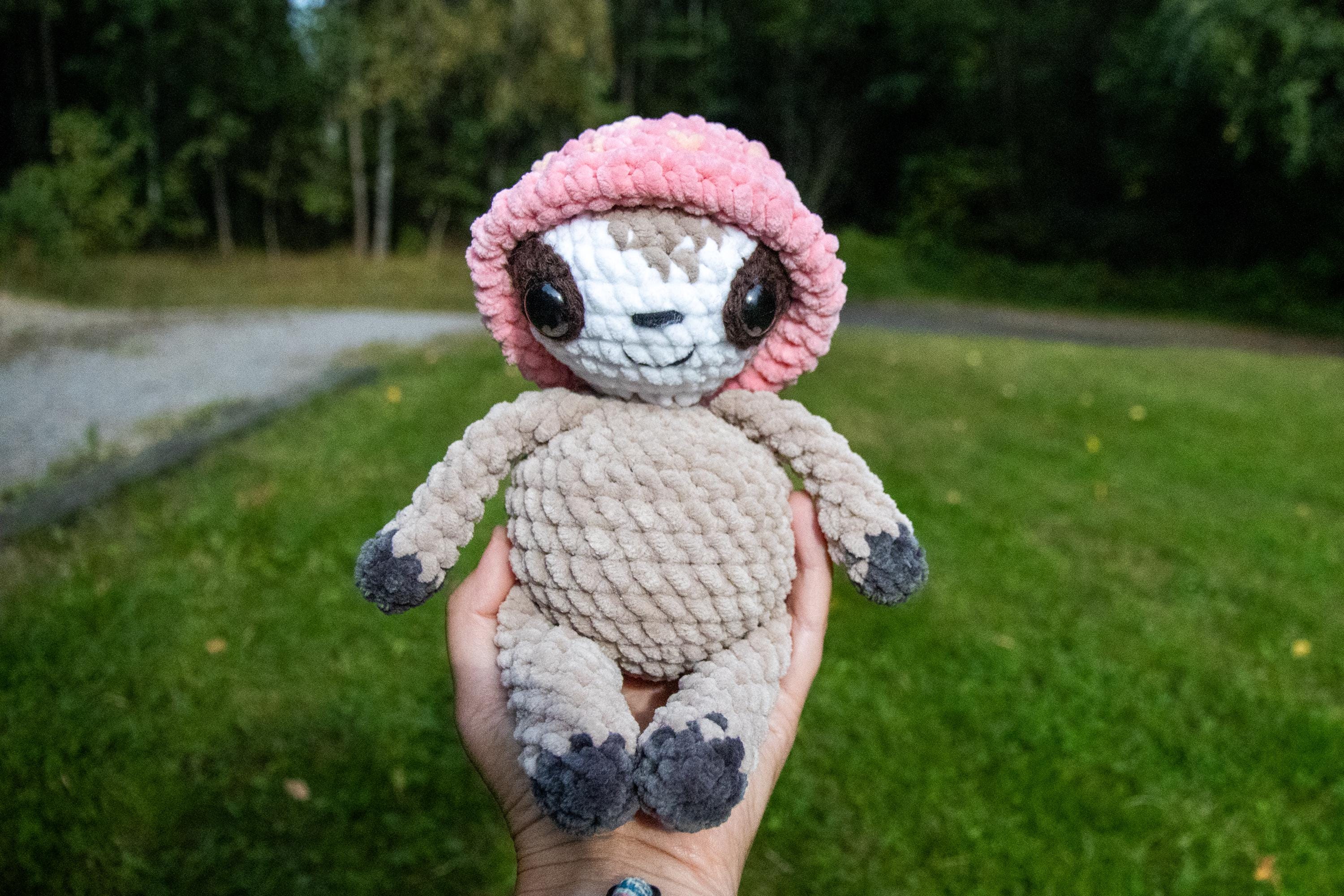 かわいいイチゴの帽子をかぶった手作りかぎ針編みのナマケモノ | かわいい手作りかぎ針編みのナマケモノ、あみぐるみナマケモノ、あみぐるみおもちゃ、赤ちゃんのための手作りおもちゃ