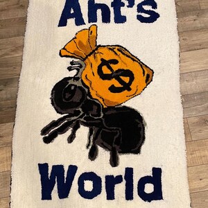 Puede incluir: Una alfombra blanca con una hormiga de dibujos animados azul y negra que lleva una bolsa de dinero amarilla con un signo de d&oacute;lar. El texto "Ant's World" est&aacute; escrito en letras azules debajo de la hormiga.