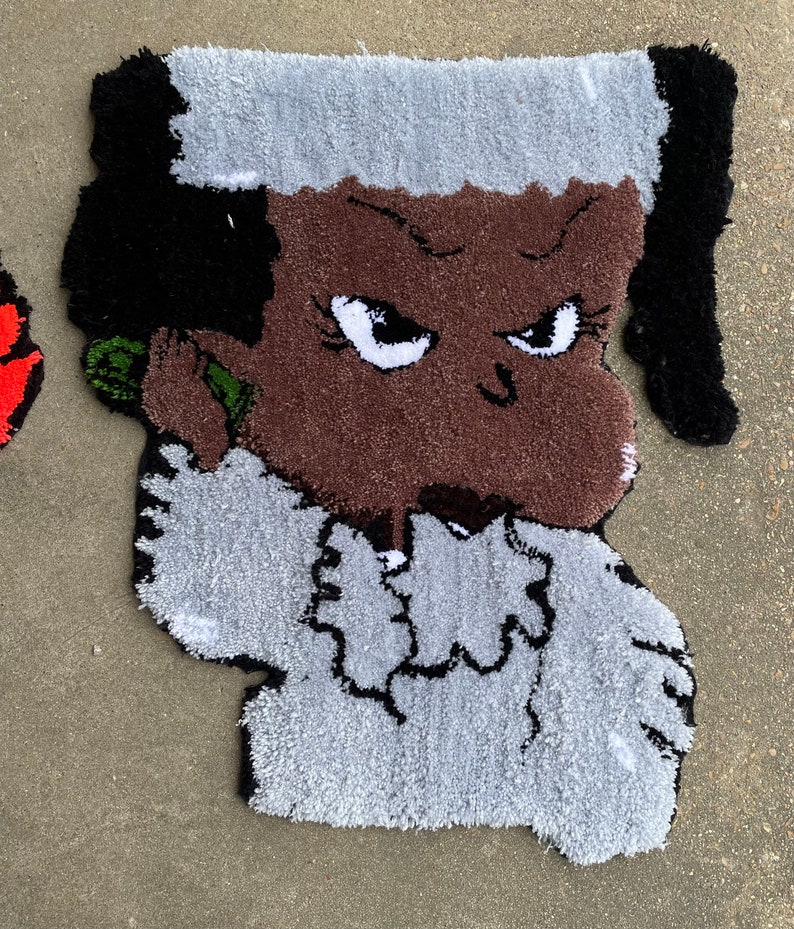 Puede incluir: Una alfombra con un personaje de dibujos animados con cabello negro, piel marr&oacute;n y una camisa blanca. El personaje tiene una expresi&oacute;n seria y est&aacute; sosteniendo un tel&eacute;fono verde en su o&iacute;do.