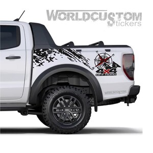 Può includere: Pick-up bianco con decalcomanie fuoristrada nere. Le decalcomanie includono una bussola, montagne e il testo "4x4 Off Road". Il camion ha ruote e pneumatici neri. È visibile anche il marchio "World Custom Stickers".