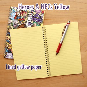 May include: A spiral-bound notebook with a colorful cover featuring cartoon characters, and the text "Heroes & NPCs Yellow." The notebook is open to reveal lined yellow paper, with a red and silver pen resting on the page. The text "Lined yellow paper" is also visible.