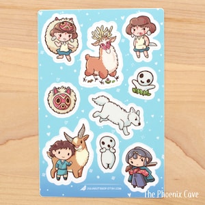 May include: A sheet of stickers featuring characters from the animated film 'My Neighbor Totoro'. The stickers are on a light blue background with white hearts and stars. The characters include Totoro, the Catbus, and the two sisters, Satsuki and Mei. The text 'The Phoenix Cave' is at the bottom of the sheet.