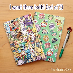 May include: Two spiral-bound notebooks with colorful cartoon character designs. One notebook has a yellow cover with various characters, and the other has a green cover with character faces. A green pen with a red flower-shaped top is also present. Text on the image reads: "I want them both! (set of 2)"