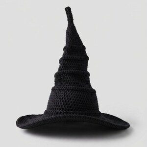 May include: A solid black pointed hat crafted with a textured crochet stitch pattern. The hat features a tall, slightly curved conical crown that tapers to a rounded tip and a wide, flexible brim that curves slightly upward at the edges.