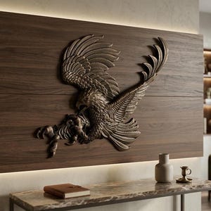 May include: A bronze-colored eagle sculpture mounted on a dark wood panel. The eagle is depicted mid-flight, with detailed feathers and talons. The sculpture is above a marble-topped table with a book and vase.