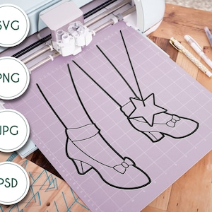 May include: A black and white line drawing of a pair of shoes with a star on one shoe. The drawing is on a purple cutting mat.