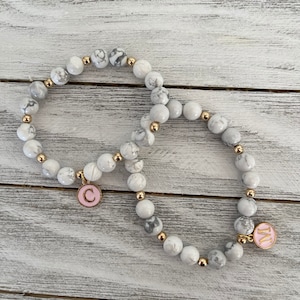 Pulseras de piedras preciosas de howlita de 8 mm y cuentas de hematita. Personalizables con tu inicial.