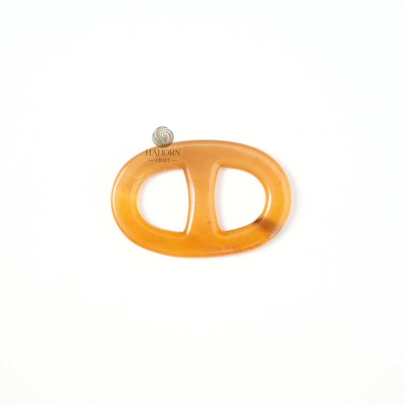 May include: A light amber-colored oval-shaped object with a central vertical bar, resembling a chain link. The object is smooth and appears to be made of a translucent material. The logo "HALIORN - CRAFT" is visible in the upper left corner. The object is set against a white background.