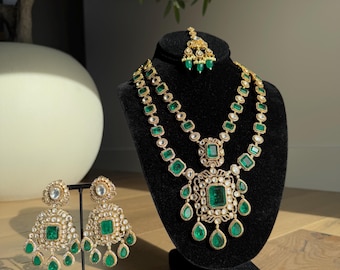 Può includere: Un set di gioielli da sposa indiani con una collana a più strati, orecchini e un maang tikka, decorato con pietre verdi e dorate.