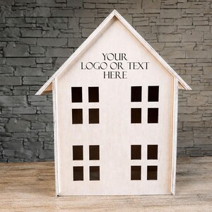 Könnte beinhalten: Eine holzfarbene, hausförmige Box mit Satteldach und acht quadratischen Fensterausschnitten. Der Text "YOUR LOGO OR TEXT HERE" ist auf der Vorderseite aufgedruckt. Das Haus steht auf einer Holzoberfläche vor einer grauen Steinmauer.