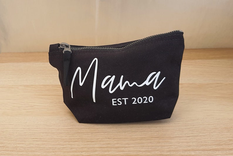 Puede incluir: Bolsa de lona negra con cremallera y texto blanco que dice "Mama EST 2020".