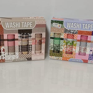 Könnte beinhalten: Zwei Boxen mit Washi-Tape-Sets. Eine Box hat ein braunes und rosa Farbschema, die andere ein grünes und lila Farbschema. Jede Box enthält 36 Rollen Klebeband, je 3 Meter lang, mit verschiedenen Mustern und Texturen.