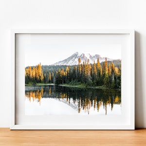 Mountain reflecting in lake with trees in mt rainier national park wall photo framed above table.